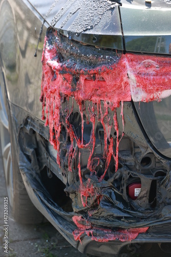 A car has been in an accident and has been covered in red paint