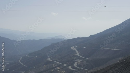 A high angle view of high mountains and serendipitous car road.