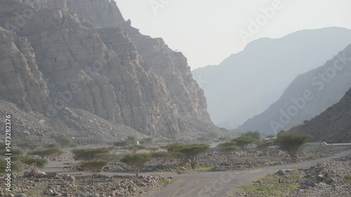 Massive rugged mountains with a car road in the deserts of the UAE.