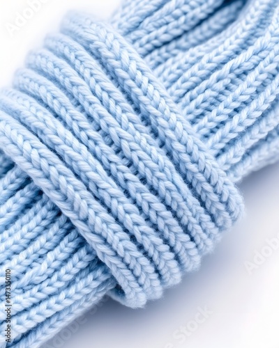 Close-up of a light blue knitted cord, showing its texture and braided pattern