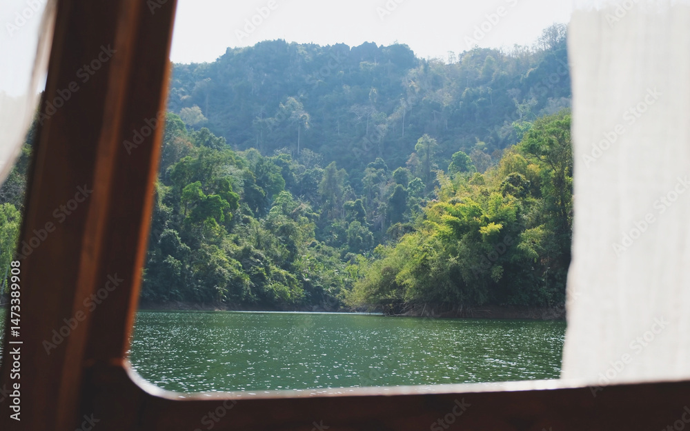 Fototapeta premium Mountain and river views from a long tail boat window