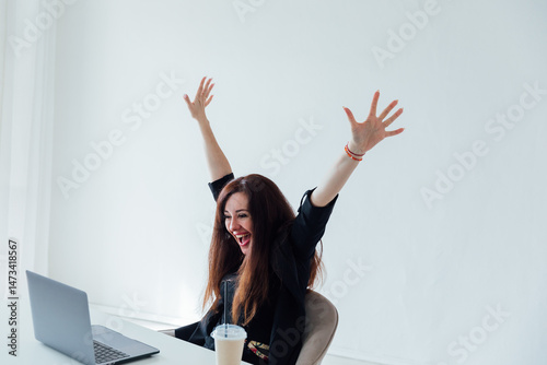 woman working on a table with a laptop happily laughing