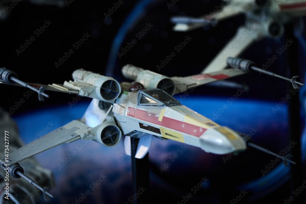 Fototapeta premium A fleet of X-wing fighter figures arranged in outer space setup in San Salvador, May 4 2025, celebrating Star Wars Day.