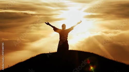 Woman Silhouetted Against a Vibrant Sunset Sky Rejoicing on Hilltop