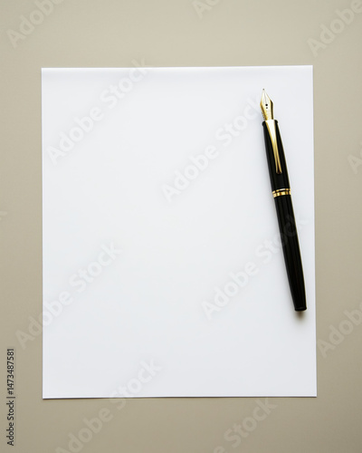A white sheet of paper on the table with a black fountain pen next to it, top view, flat lay.
