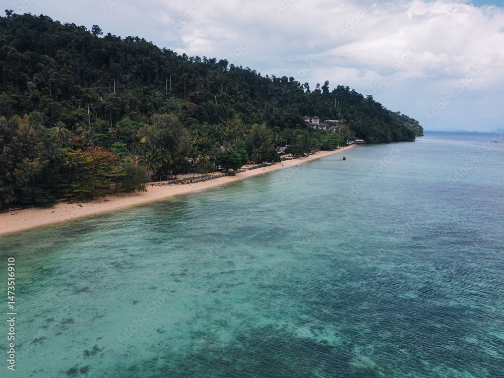 Fototapeta premium Stunning aerial view of a pristine beach meeting a lush rainforest on the tropical island of Koh Ngai, Thailand, offering a serene escape