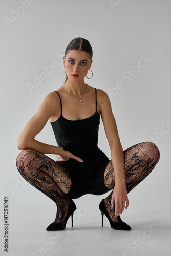 Photography Beautiful, seductive woman sitting in sexy pose wearing alluring stockings and h