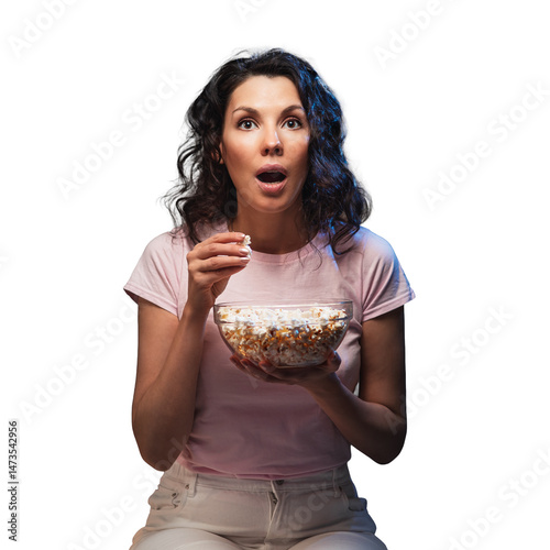 Young beautiful woman stay home, during pandemic, spends his free time watching TV on couch at home, wonder and scared. Girl watching projector movies with popcorn in evening