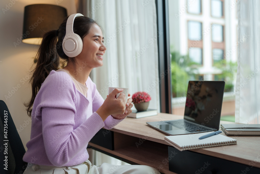 Fototapeta premium Young woman enjoying music and coffee during work from home