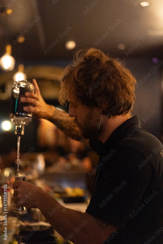 Naklejka premium A bartender makes cocktails in a night bar
