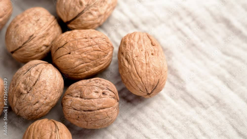 Close up of walnuts on fabric kitchen tablecloth top view. Rotation