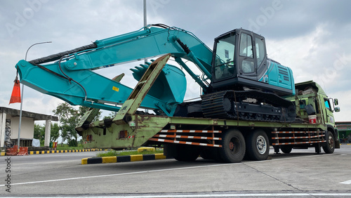 Heavy new excavator on transportation truck