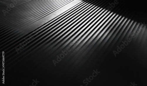 A black and white close-up view of parallel lines, creating a sense of depth and perspective.  Light source illuminates the lines, casting shadows