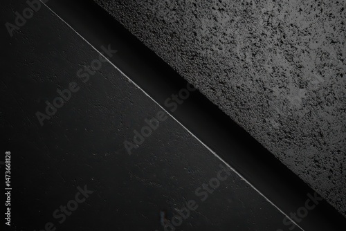 Abstract angled dark gray textures. Two contrasting surfaces meet in a sharp diagonal