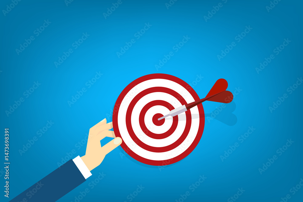 Hand holding a target, showing a goal. Red arrow hits the center. Business challenge failure and success concept. Hand holding a target, showing a goal. Red arrow hits the center. Business challenge failure and success concept.