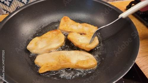 Homemade dough in hot oil in frying pan. Golden Fried Dough in Hot Oil on Frying Pan