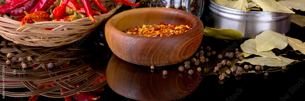 Spices and herbs, bay leaf, black pepper and wooden bowl of chili flakes