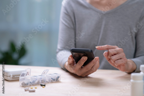 Wallpaper Mural Middle aged woman checking medication reminder on phone. Torontodigital.ca