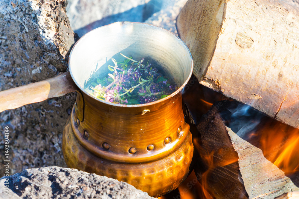 Making herbal tea in cezve on campfire