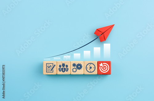 Принти на полотні Red paper plane and wooden cubes with business strategy icons