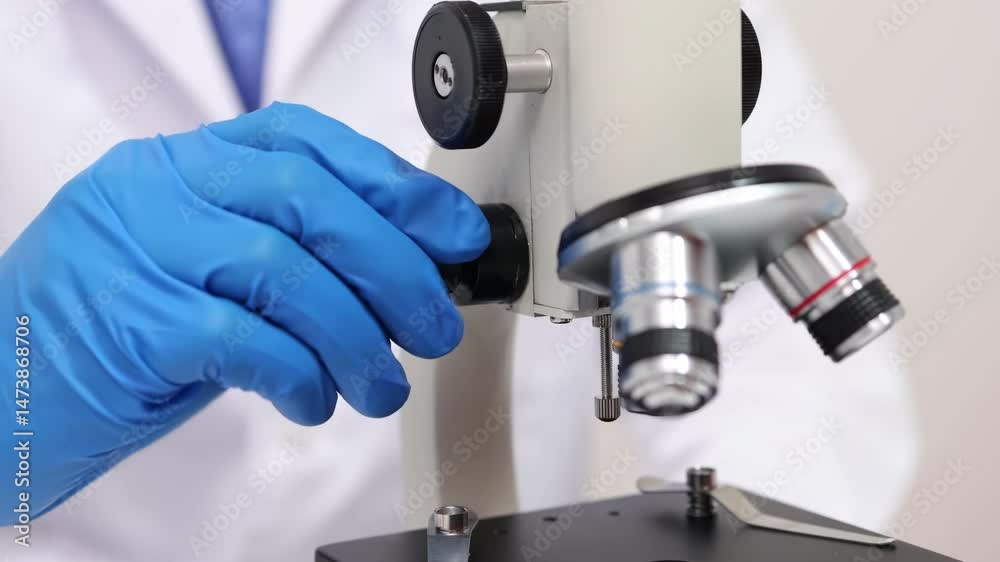 A scientist works tirelessly in a lab examines samples through a microscope, highlighting advances in gene therapy and its applications A scientist works tirelessly in a lab examines samples through a microscope, highlighting advances in gene therapy and its applications
