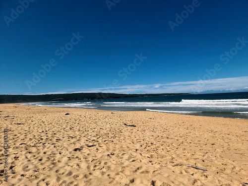 Beautiful sandy Aslings Beach with waves crashing onto the shore. Taken at Eden on the New South Wales far south coast Australia
