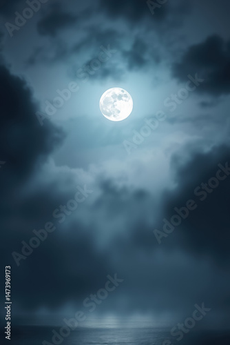  A large, luminous full moon shines brightly in a night sky, surrounded by dark, scattered clouds. Its reflection gently illuminates the calm surface of the water below, creating a serene atmosphere.