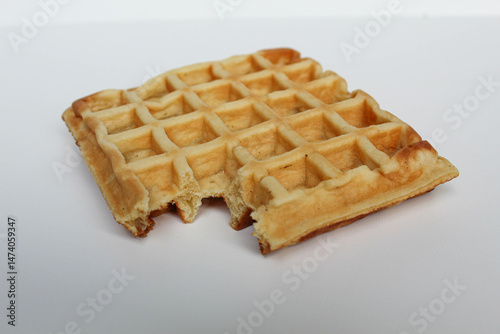 One bitten waffle cake, isolated on white background