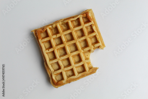 One bitten plain waffle cake, isolated on white background, flat lay or top view