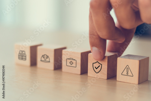 Work safety and compliance concept. Wooden cube blocks with icon of safety at workplace. Safety first, protections, health, regulations and compliance. Safety in working process. Zero accidents.