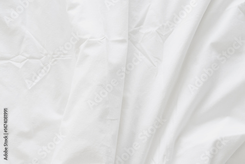 Abstract background of rippled white silk fabric, white fabric draped in soft waves empty bed sheet. Close up image.