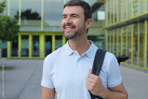 Handsome elegant man walking outdoors with a backpack 