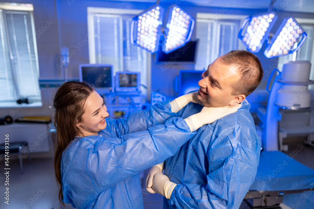 Obraz premium Surgical team shares a laugh. Medical professionals in scrubs share a playful interaction inside a bright hospital room during a break.