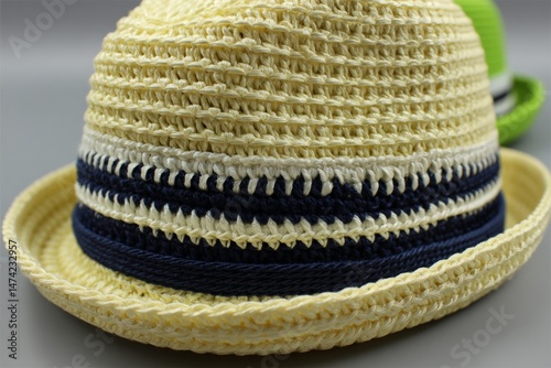 Colorful straw hats in various styles displayed together at a market booth on a sunny day