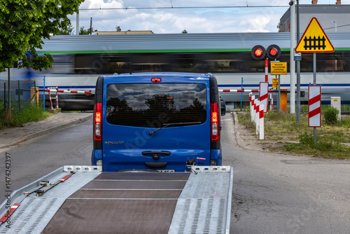 Schilderij op canvas Cars waiting at a level crossing, a high-speed express train passes through a cl