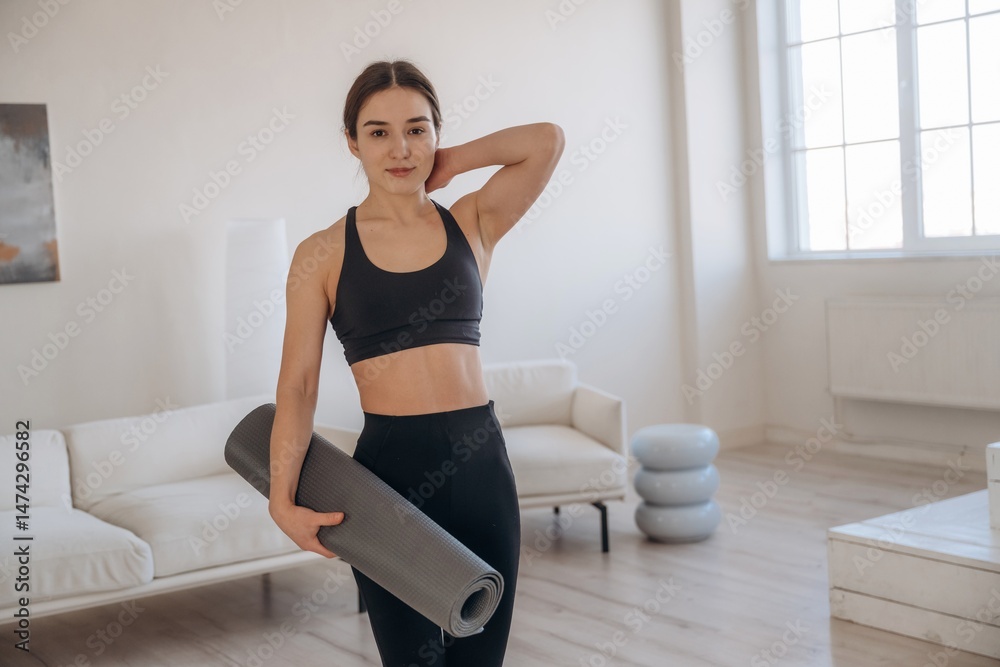 Fototapeta premium In domestic room. Yoga woman is at home with mat