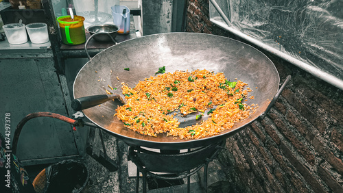 An Indonesian specialty, the delicious Nasi Goreng Merah is cooked in a large wok on an outdoor stove