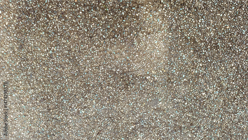 Detailed close up of a pebble stone paved road surface with light reflection