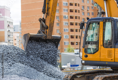 Heavy machinery for construction and landscaping. An excavator on a construction site in close-up. An excavator loads crushed stone into a bucket for construction.