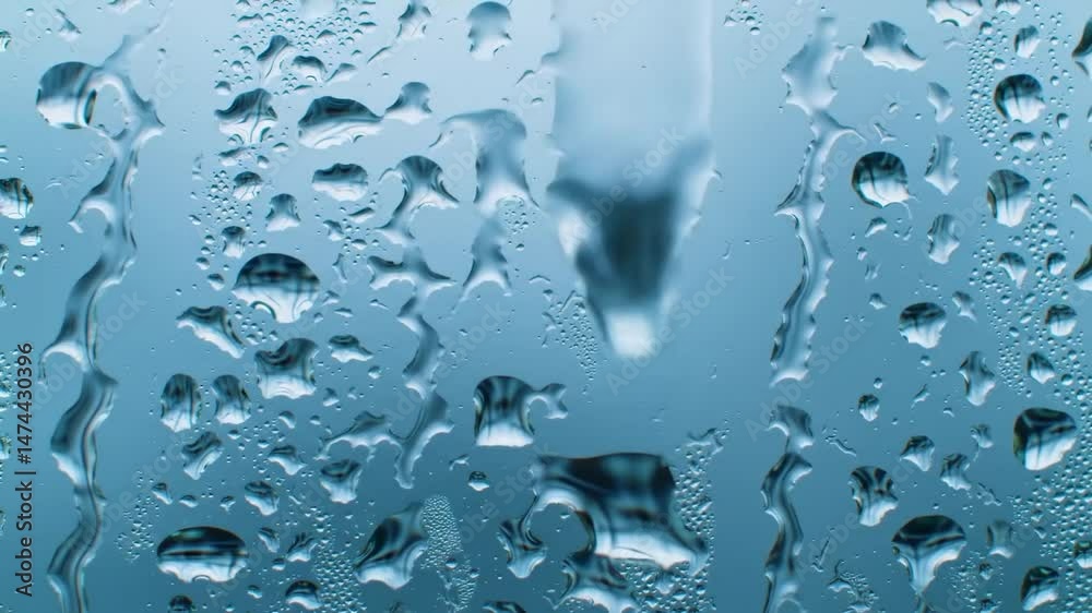 Water droplets on glass with a clear blue background.