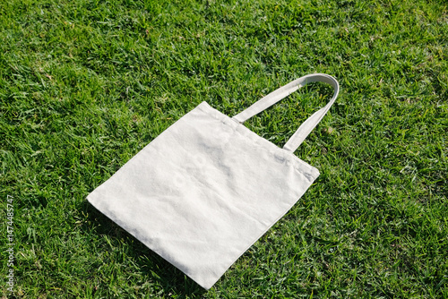 Canvas tote bag lying on green grass outdoor photo