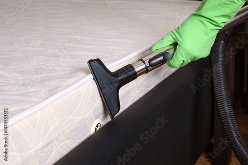 Professional cleaning and disinfection services use an industrial vacuum cleaner to clean the mattress.