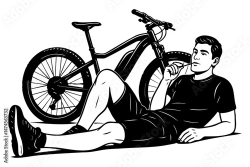Young man in sportswear relaxing on the ground near a mountain bike and chewing a straw
