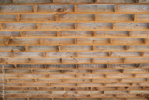Wooden grid ceiling frame revealing intricate architectural pattern, highlighting skilled carpentry and elegant structural design with raw timber elements
