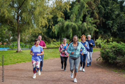 Group of active senior people doing running sport workout at city park - Healthy elderly lifestyle concept	
 - Soft focus on african woman
