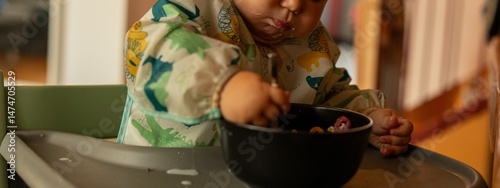 Cute baby happily eating cereal.  Perfect for family, food, and parenting blogs.