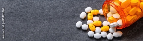 A close-up of spilled yellow and white pills from an orange prescription bottle against a dark background, ideal for health, pharmaceutical photo