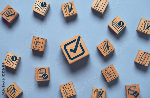 Correct tick sign mark on wooden block cube among document preparation check and approve for ISO and quality audit concept.