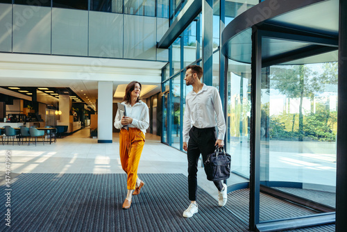 Coworkers arriving at modern office building entrance photo
