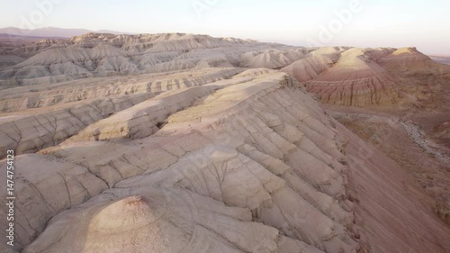 Sunset among the chalk mountains is like on Mars. A bird's-eye view of the gorge through which water used to flow, white peaks and red edges. Paleontological deposits. Layered rocks look like bastions
